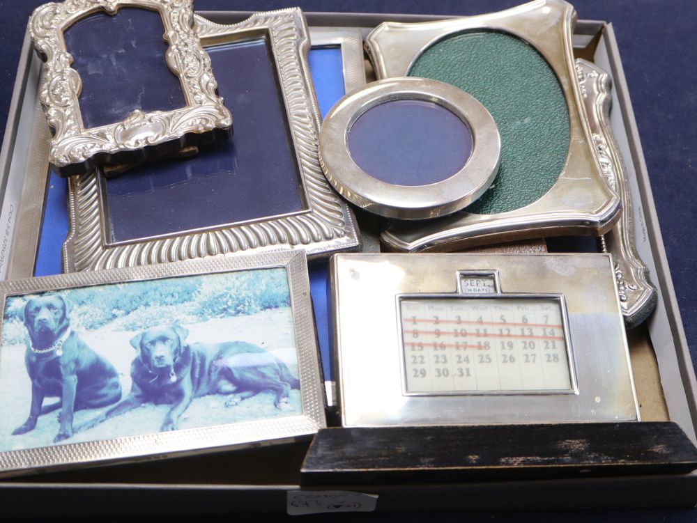 Eight assorted George V and later silver mounted photograph frames and desk calendar, largest 24.5cm.